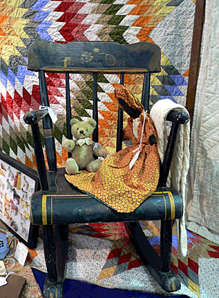Painted rocker and quilt.